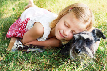 Happy cute little girl hugging her little dog