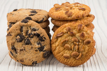Biscuits with chocolate and peanut on old wooden table.