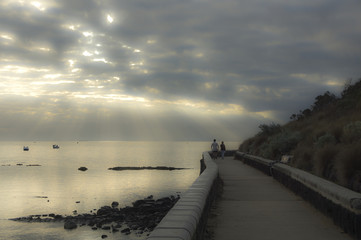 Misty bay at sunset with walkers