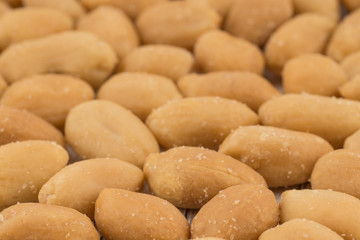 Salted peanuts on white old wooden table.