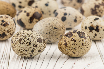 Quail eggs on old white wooden table.