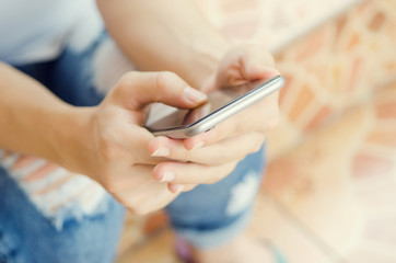 Close up of women's hands holding cell telephone, hipster girl watching video on mobile phone.