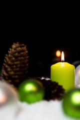christmas ball, fir cones and candles in the snow, copyspace