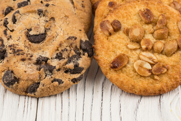 Biscuits with chocolate and peanut on old wooden table.