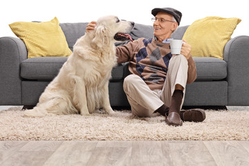 Man sitting on the floor and petting his dog