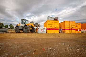 Radlader auf Baustelle mit container