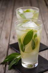 Pear lemonade with lime and sage on wooden background, selective focus