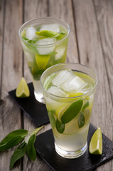 Pear lemonade with lime and sage on wooden background, selective focus