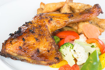 Roast chicken thigh with potato wedges and sauteed vegetables