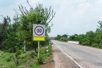 Round speed limit 30 road sign in village