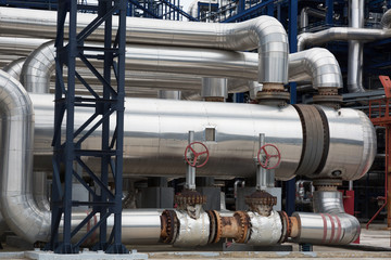 Fototapeta na wymiar Close-up of pipelines and destillation tanks of an oil-refinery plant