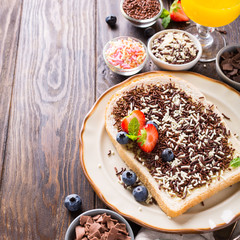 Dutch breakfast, slice of bread with hagelslag chocolate sprinkles and berries. Copy space.