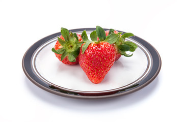 fresh garden strawberries on a white plate