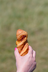 Woman holding cheese straw pastry in hand