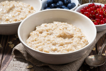 homemade oatmeal and berries on wooden table, closeup
