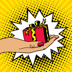 Pop art background with female hand holding a gift. Vector hand drawn illustration in retro comic style.