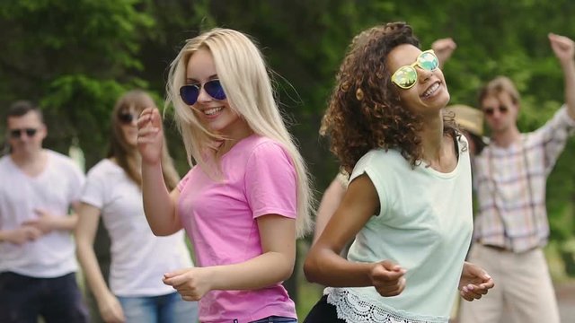 Two girls dancing at open-air dance audition, happiness and youthfulness, party
