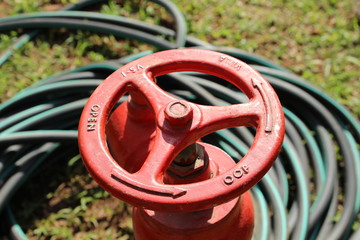Red metal water leaver for gardening with a garden hose