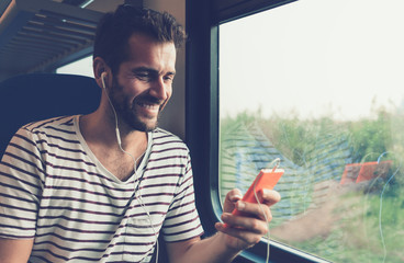 Young man listening to the music on the train