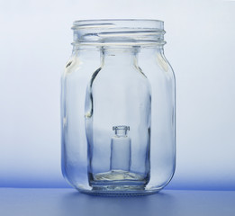 Jar within jar within jar.  See through jars, showing blue refraction through clear glass and soft blue background