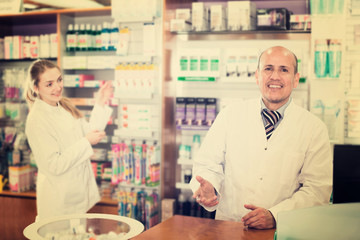 Fototapeta na wymiar Pharmacist and assistant working at farmacy reception