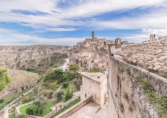 Fototapeta premium panoramic view of typical stones (Sassi di Matera) and church of Matera under blue sky