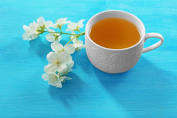Obraz na płótnie Canvas Cup of tea with jasmine flowers on wooden background