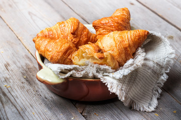 Fresh croissants for breakfast on rustic table