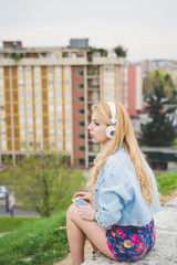 Young beautiful blonde caucasian girl listening music