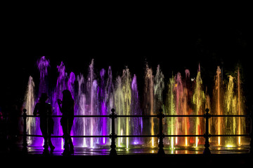 Girls looking at a colorfull fountain