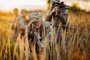 Rangers shooting with his weapon, rifle at sunset. War, army
