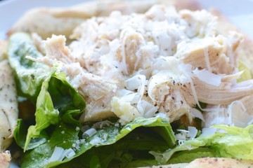 Close up view of Chicken caesar salad with parmesan shavings