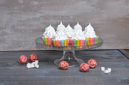 rainbow cupcakes on cakestand with rottan decoration