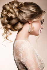 Beautiful bride with fashion wedding hairstyle - on beige background.Closeup portrait of young...