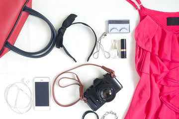 Flat lay of fashion items with film camera, smartphone, red hand