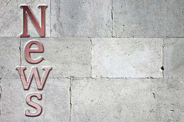 News carved on white stone wall
