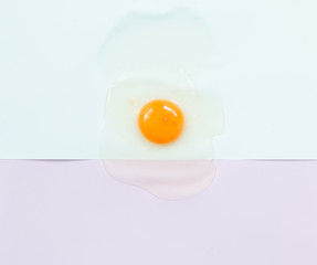Top view of raw egg on pastel background.