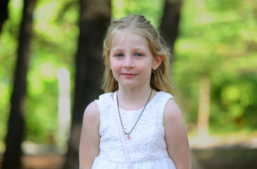 caucasian little blonde girl with blue eyes  in forest