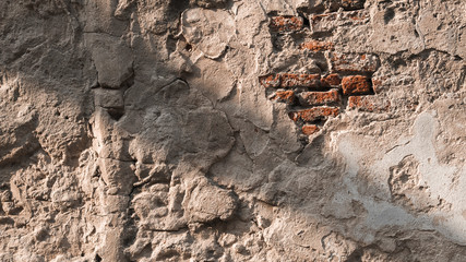 Background of cracked ancient  wall which show the brick on the top right and the shadow lean across the wall from top left to button right