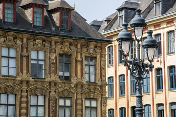 One lantern and two ancient buildings as background in the day in Lille, France