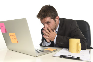 attractive businessman looking worried in stress at office laptop computer having work problem