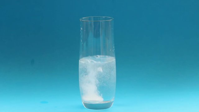 an effervescent tablet for  migrain attack/ a glass wtih  an effervescent tablet