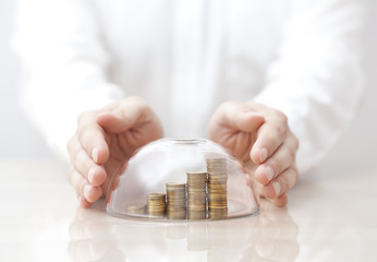 Rising coins protected under a glass dome and hands © Jakub Krechowicz