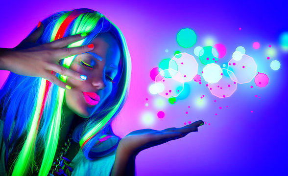 Fashion woman in neon light. Beautiful model girl with fluorescent make-up