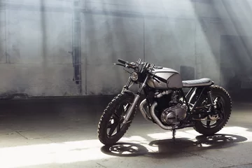 Photo sur Plexiglas Moto moto debout dans un bâtiment sombre dans les rayons du soleil