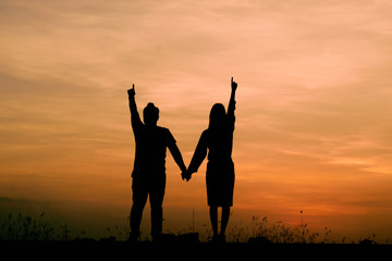 Silhouettes of couple against the sunset sky