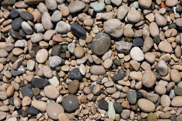 texture of beautiful wet round colored sea pebbles on pebble bea