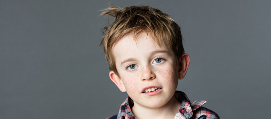 adorable mischievous young kid with freckles and messy red hair