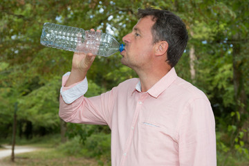 Close up of man drinking water from a bottle outside