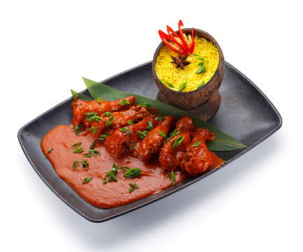 Seychelles food. Rice in a coconut plate and chicken with curry isolated on white background